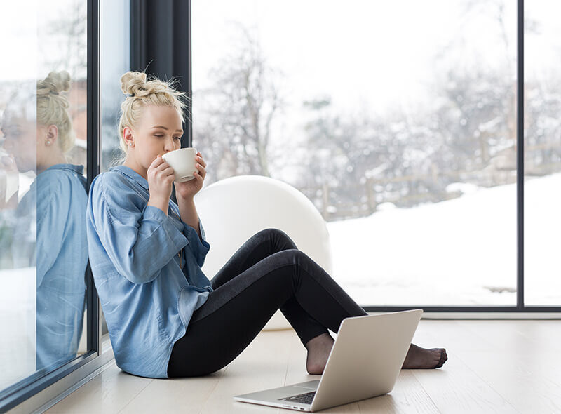 A Lady Drinking Coffee sitting near thermal break steel window